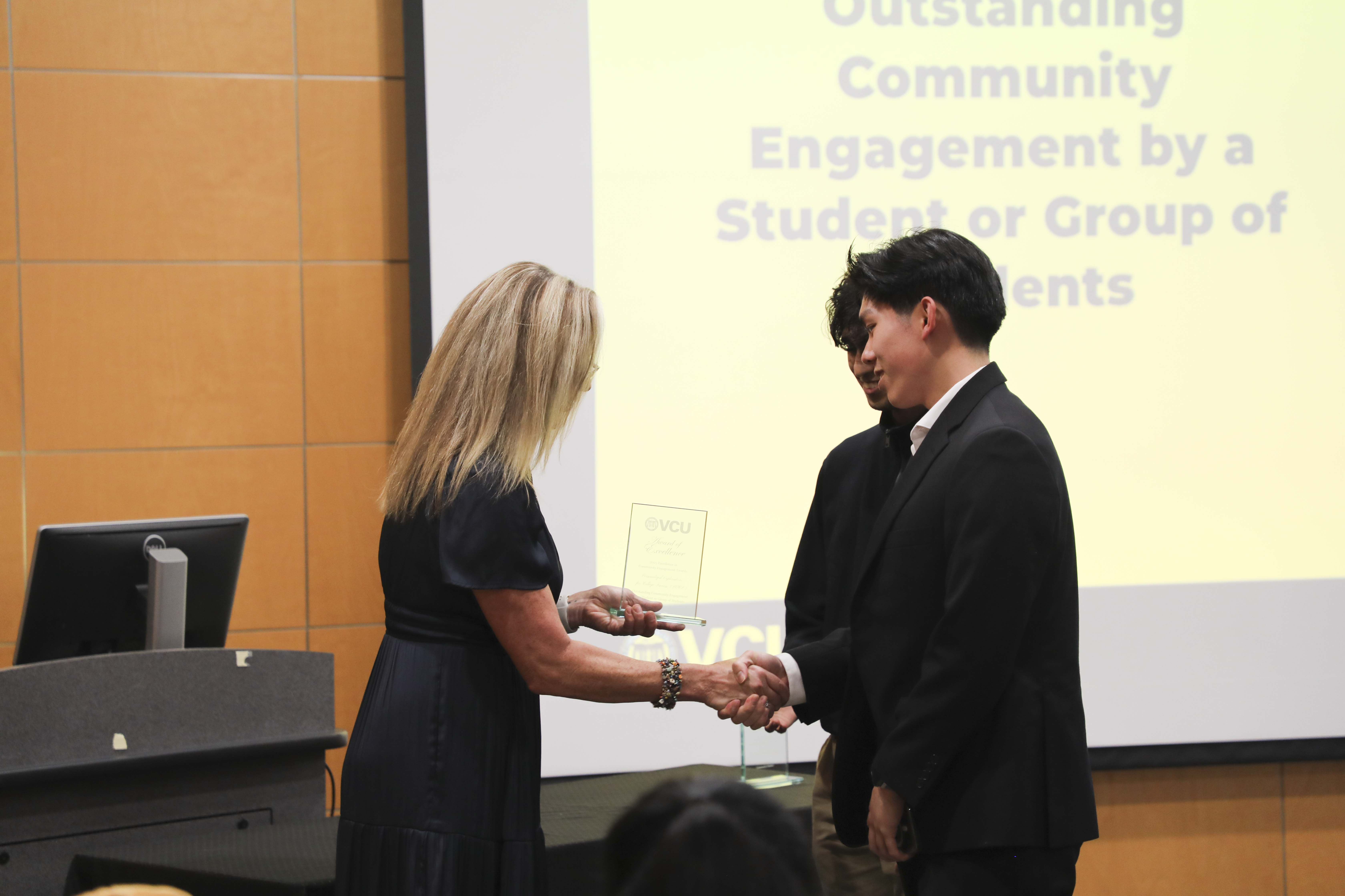 students receiving a plaque