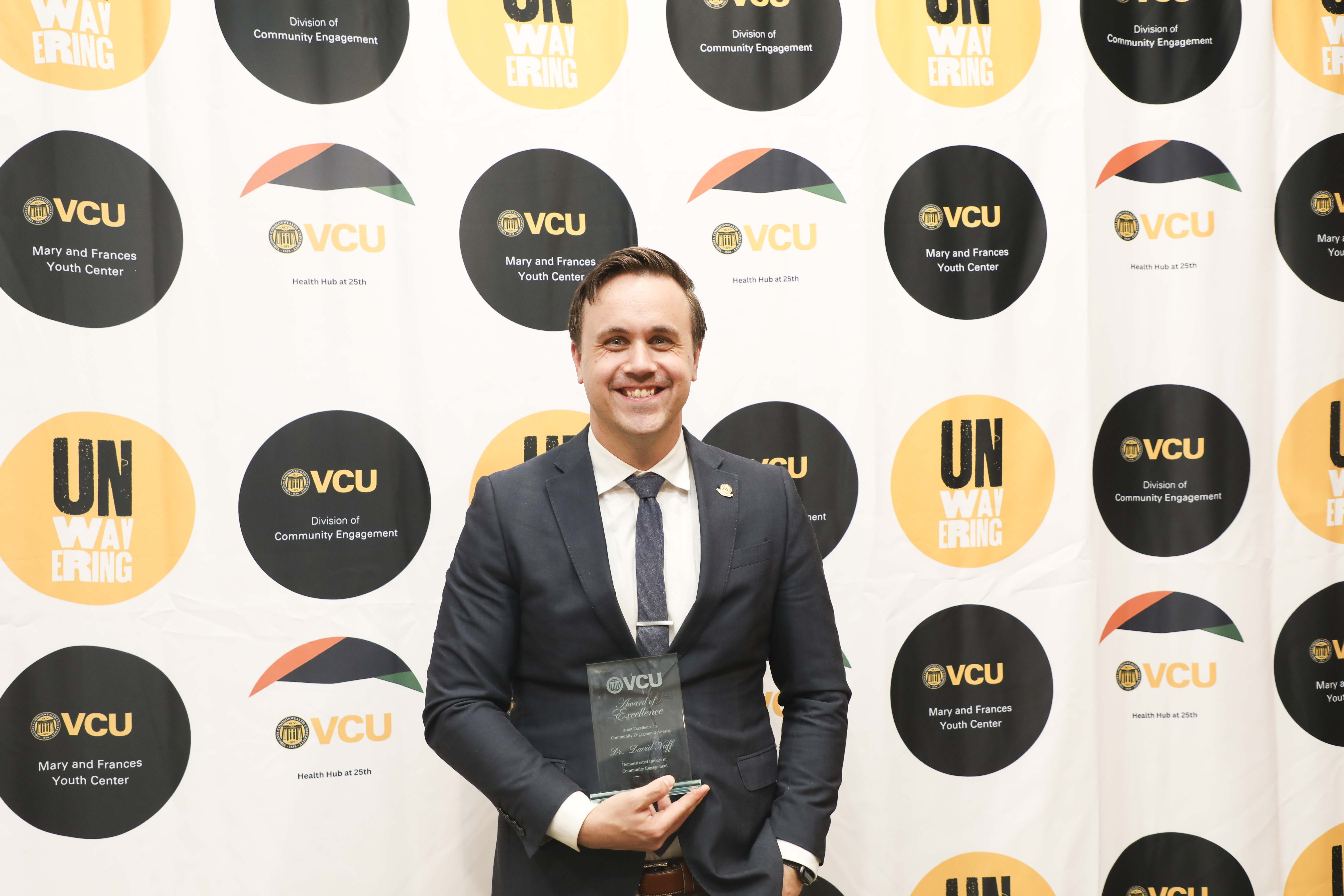 man posing with plaque