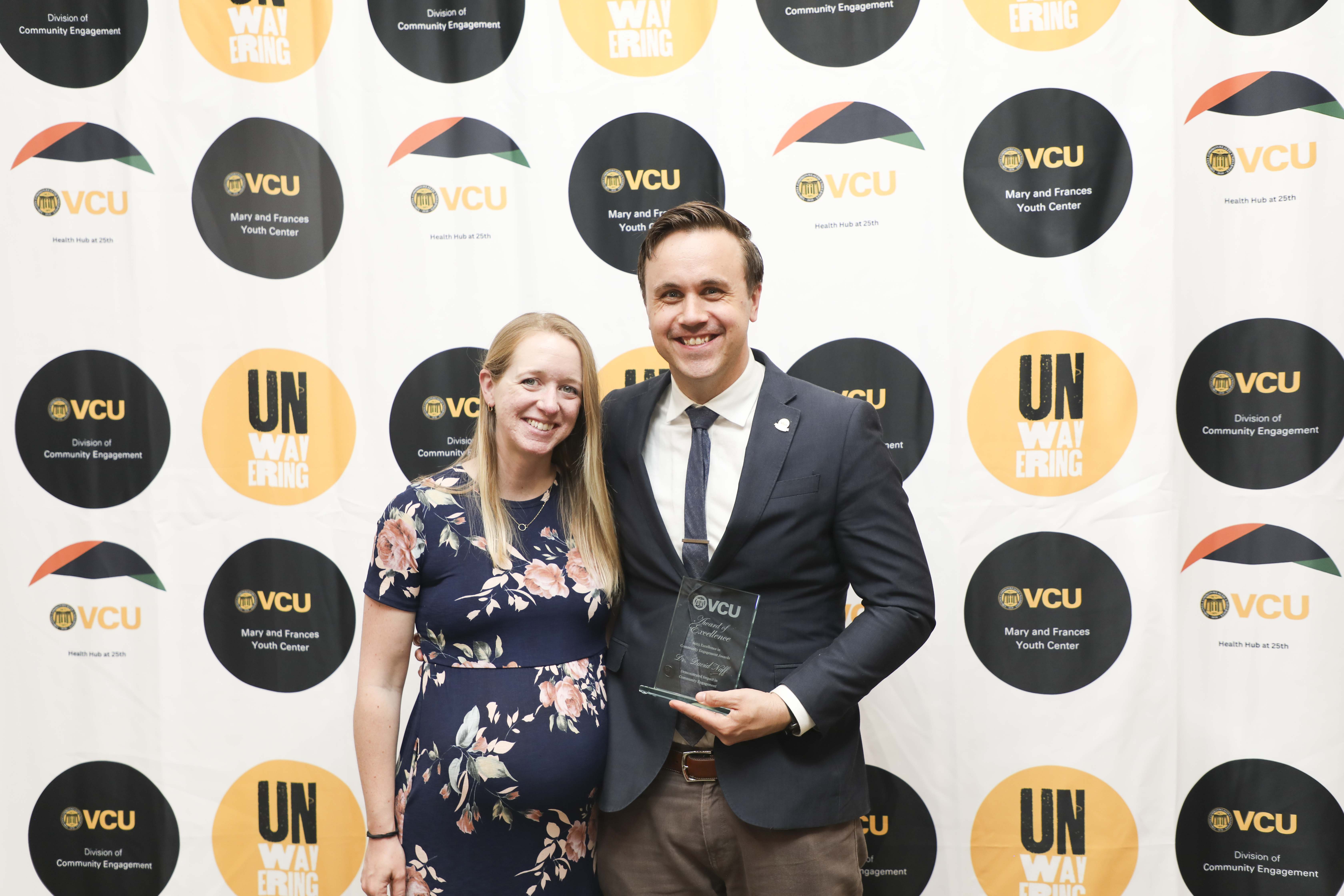 man and woman posing with plaque