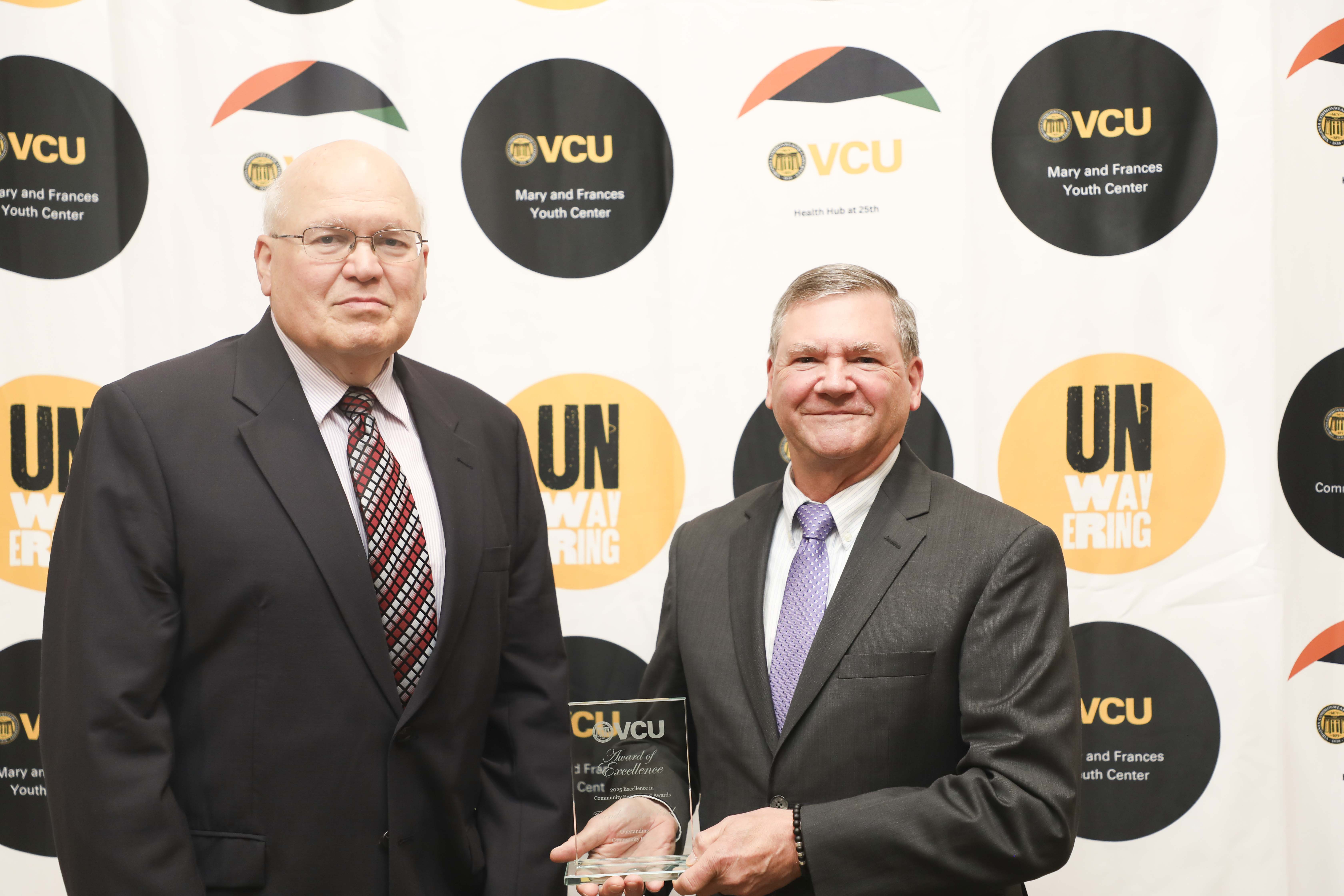 two men standing with plaque