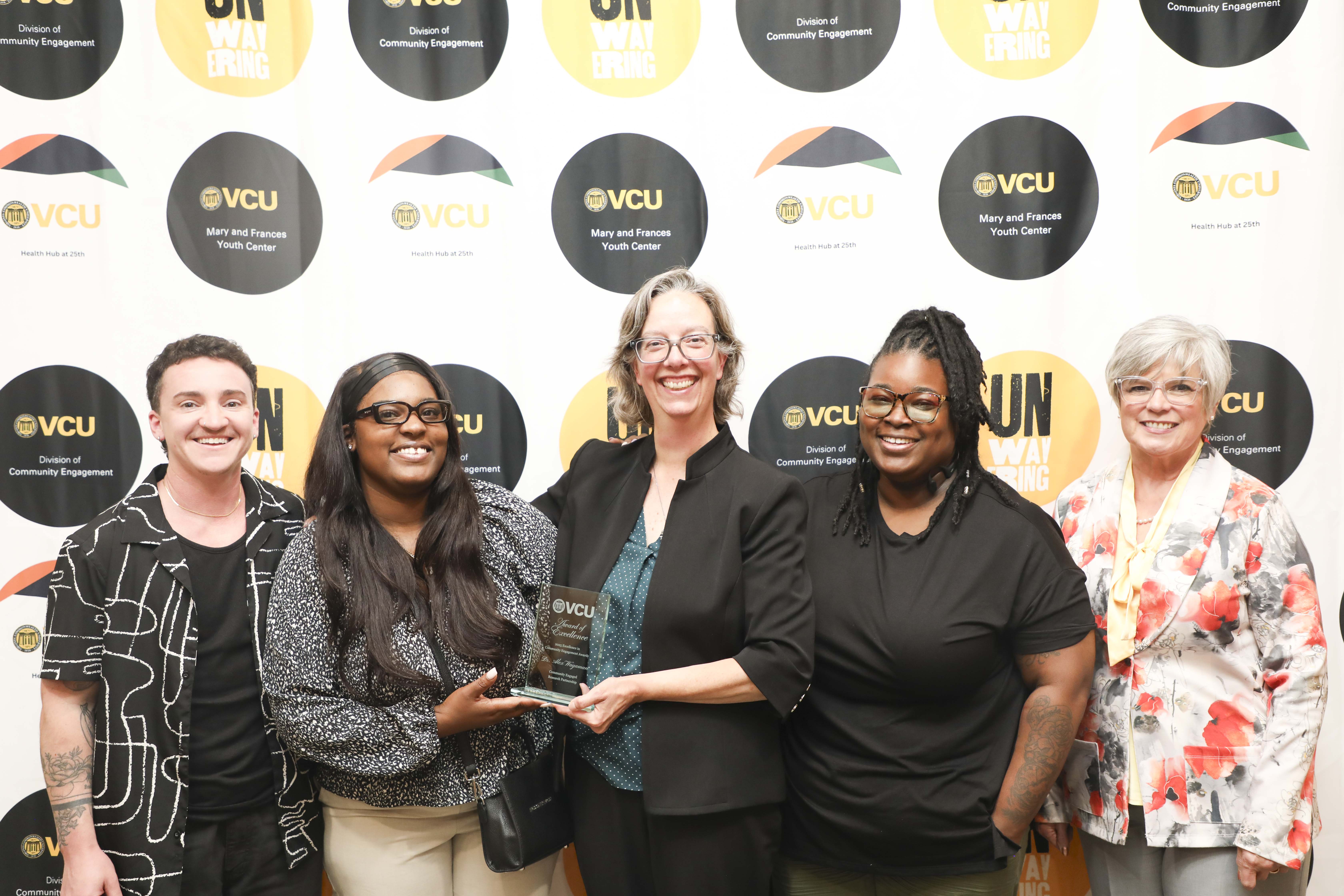 group posing with a plaque