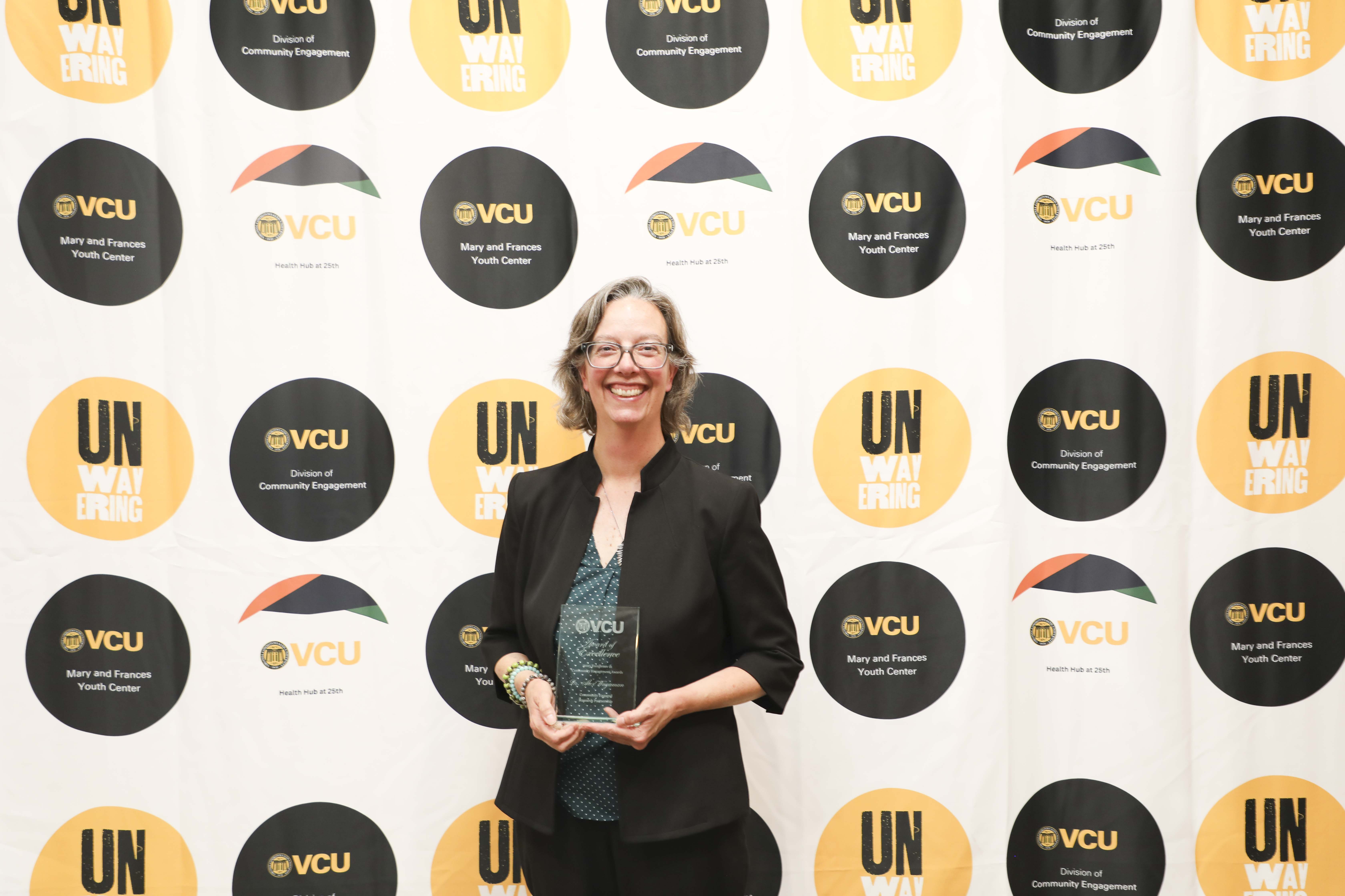 woman posing with plaque