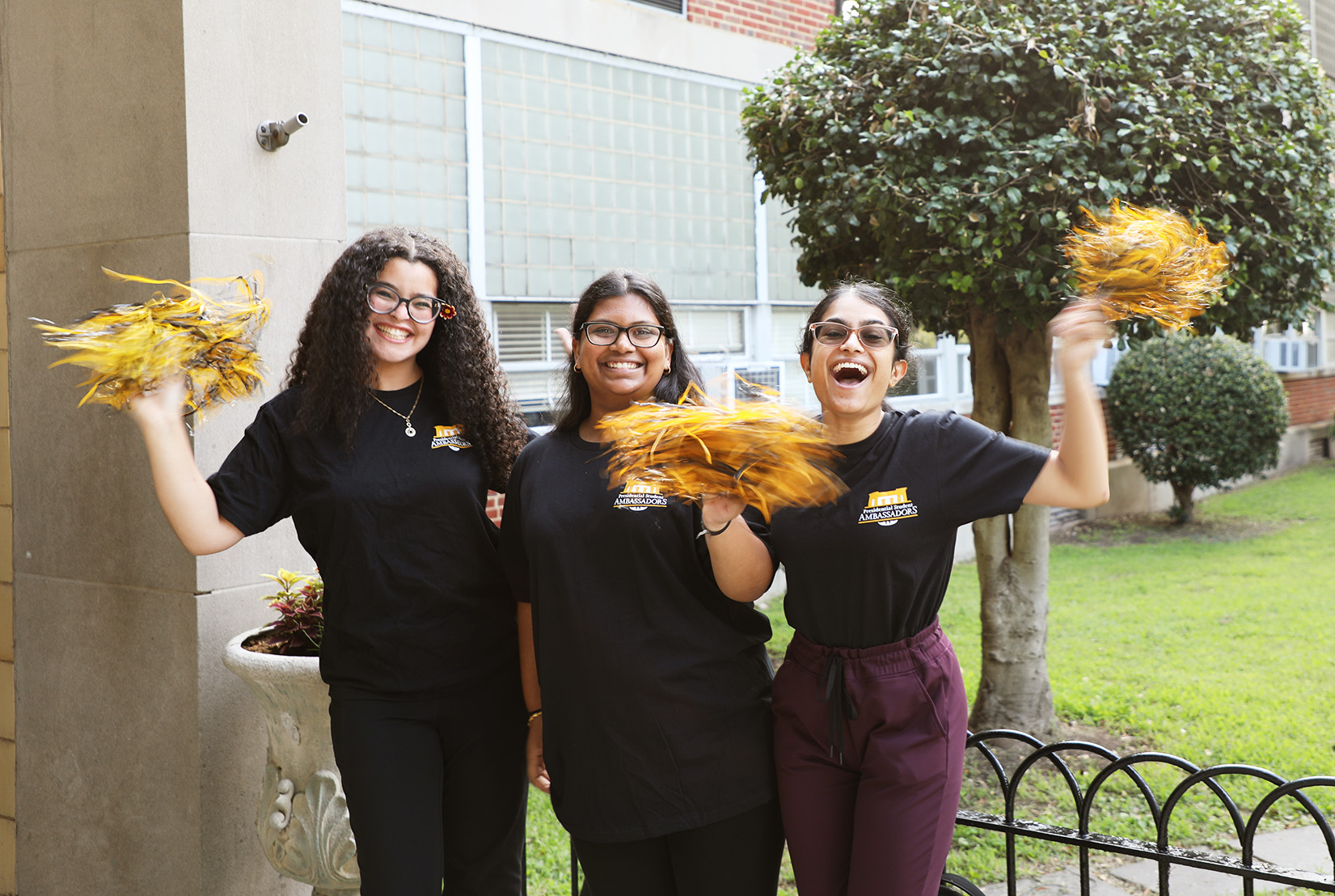 VCU students smiling and waving pom poms