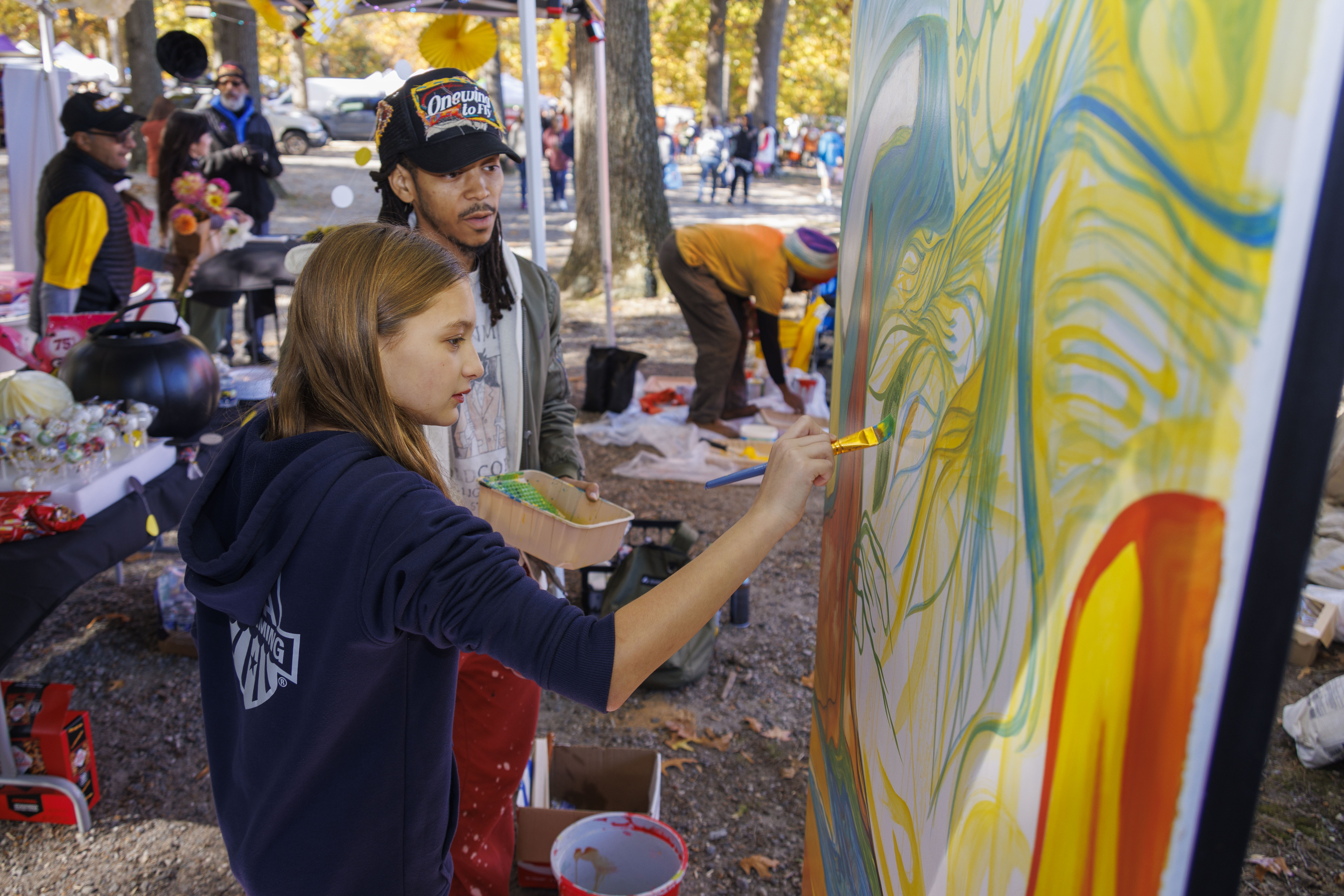 two community members painting a mural