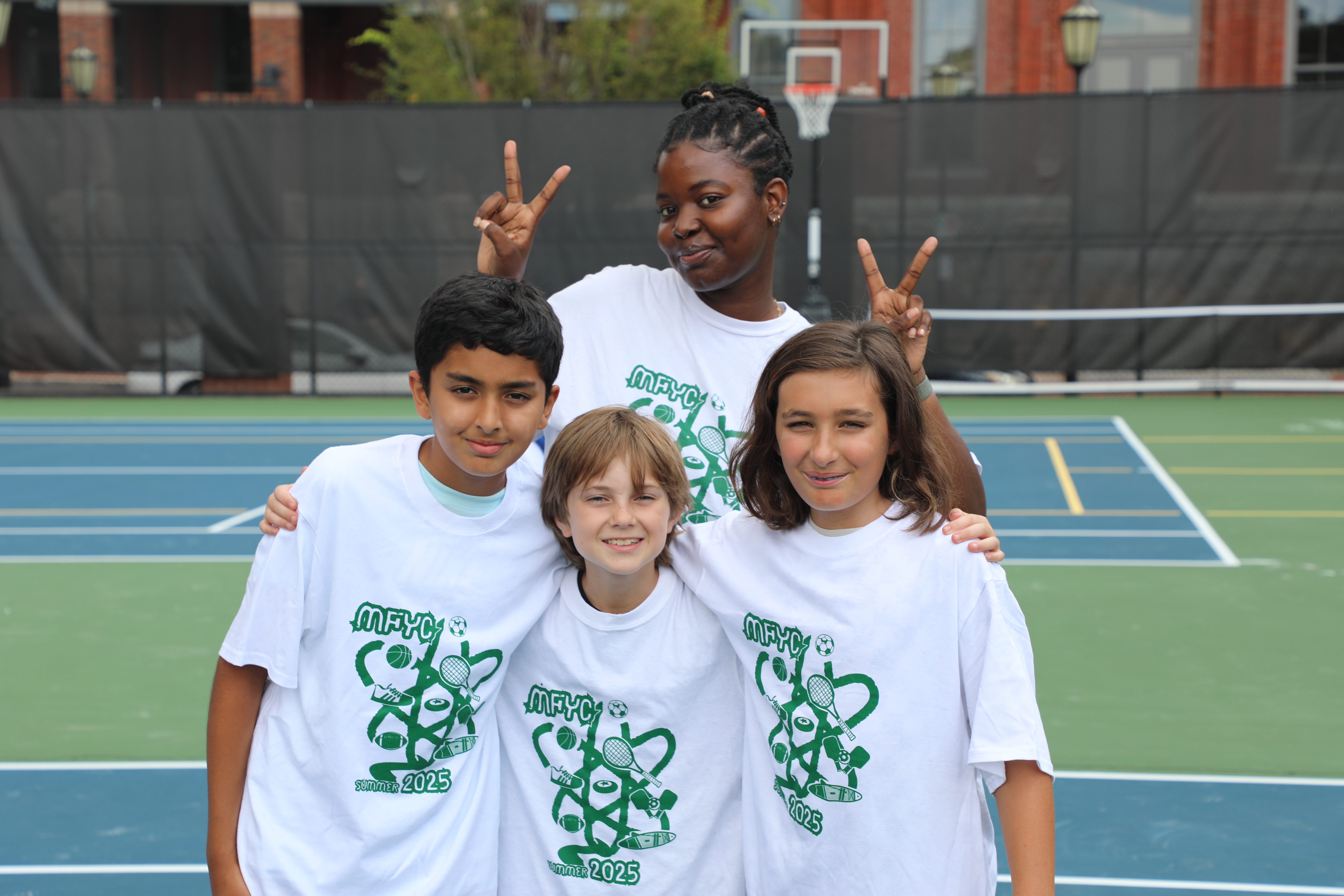 A group photo of youth with a camp counselor