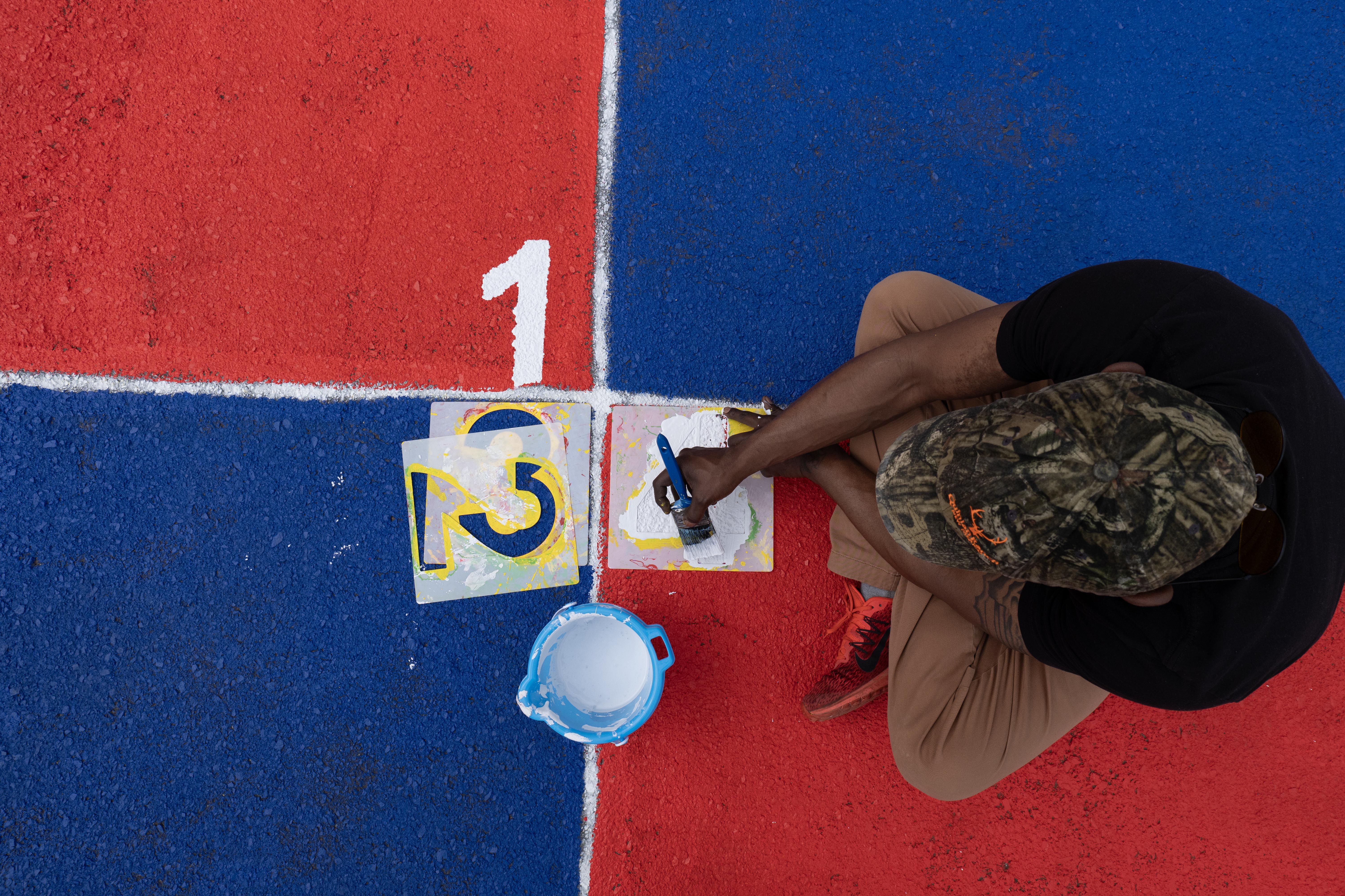 A boy painting squares on the ground