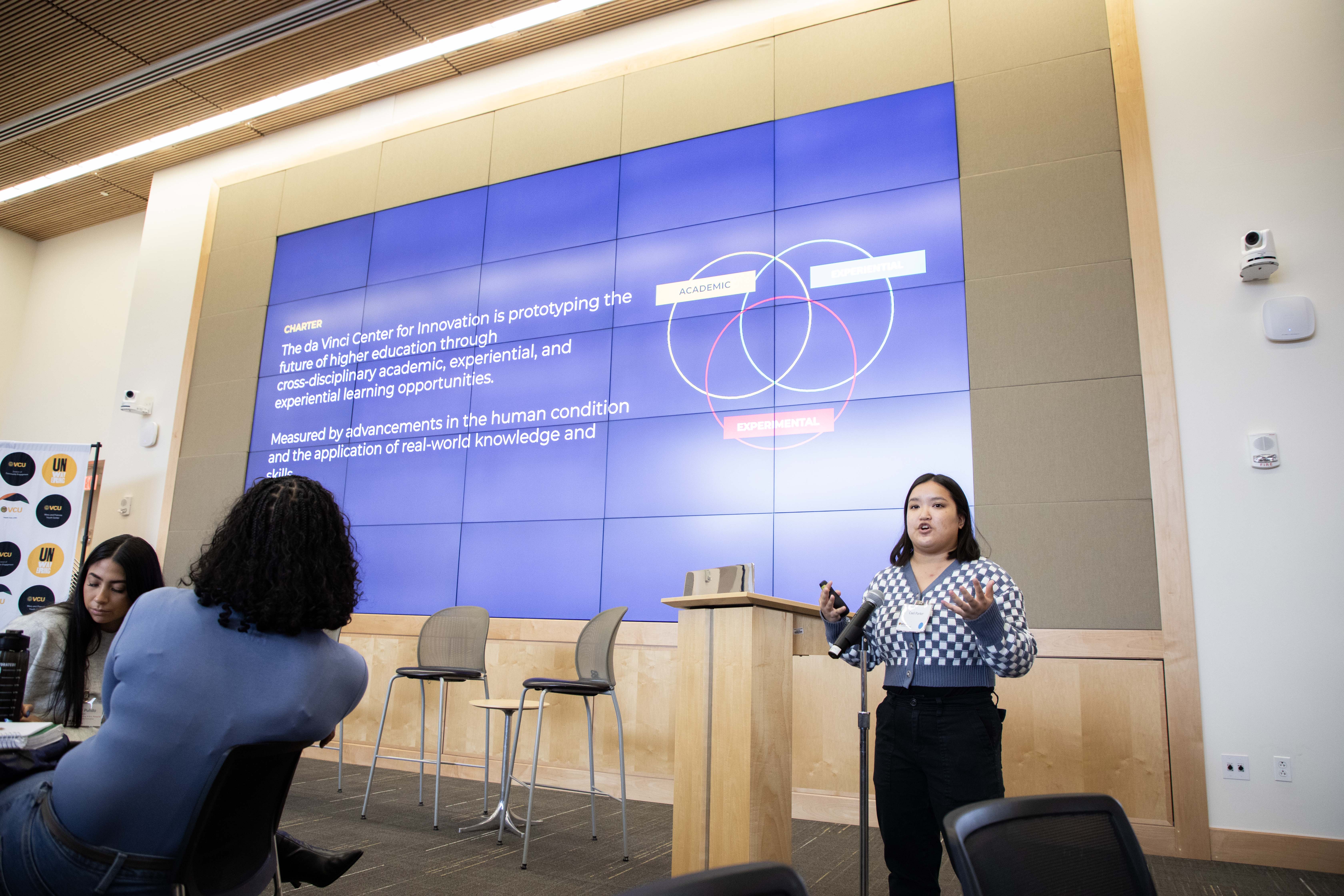 A woman talking into a microphone giving a presentation