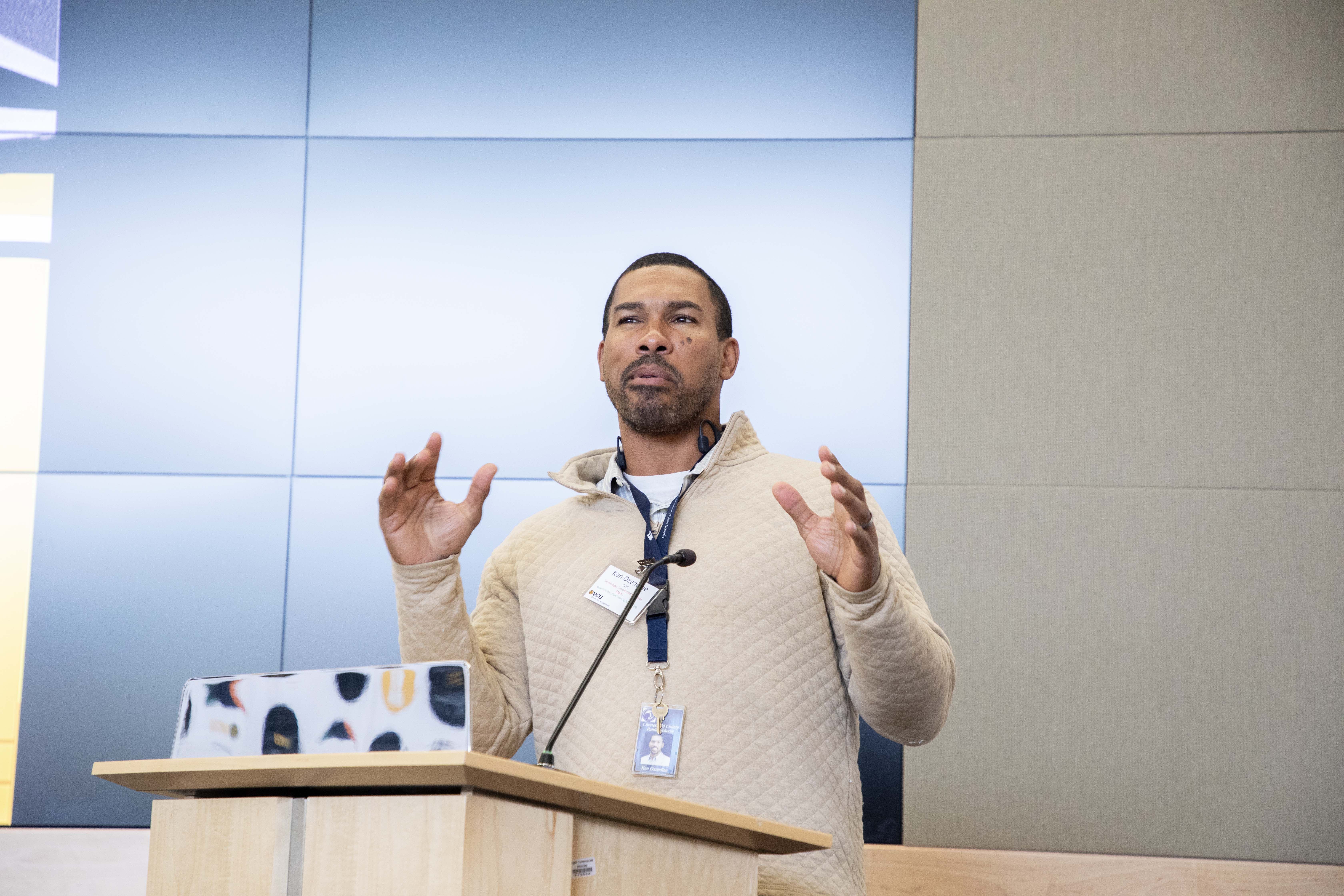 A man speaking into a microphone at a pedestal